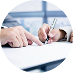 Two individuals signing a document together with a pen